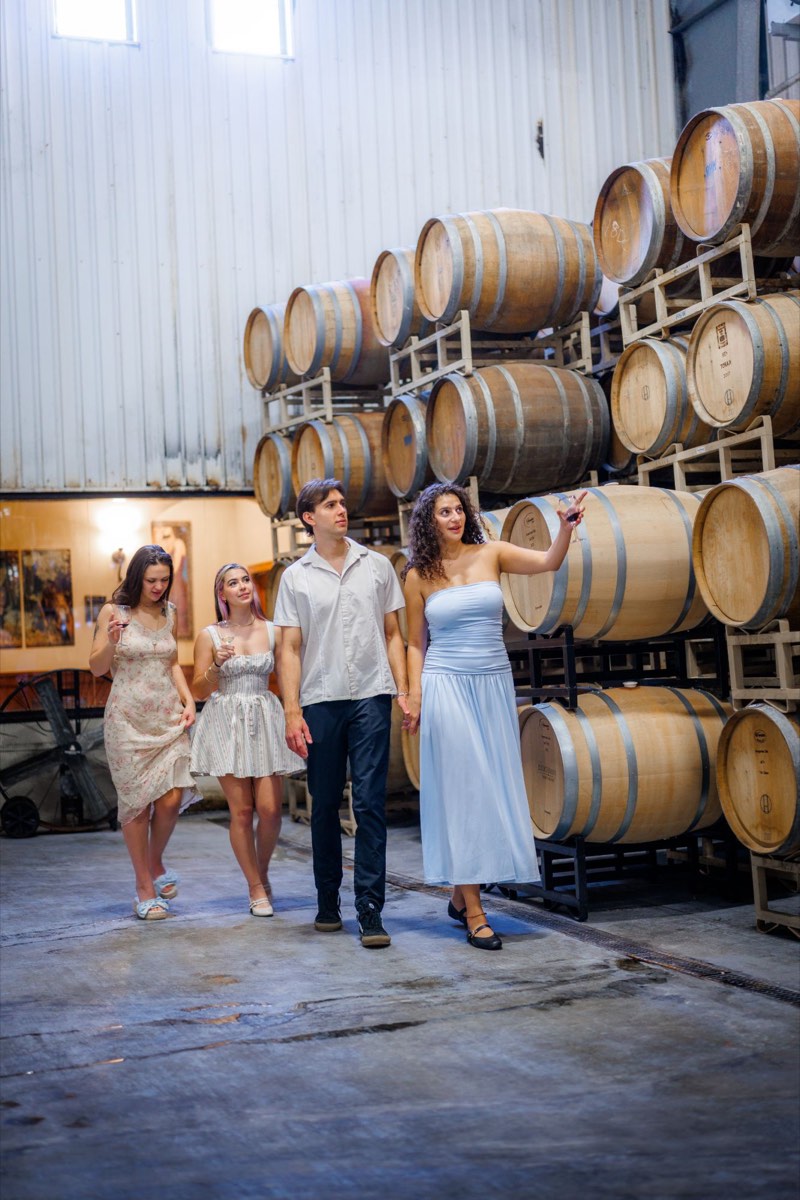 Guests with wine walking through a winery barrel room